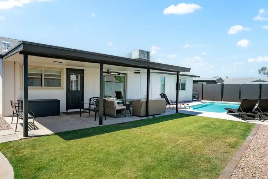 Covered patio and lawn with the pool beyond
