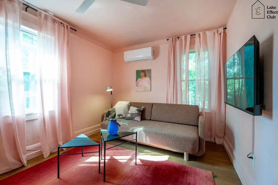 Bright living room with a red rug and sheer curtains