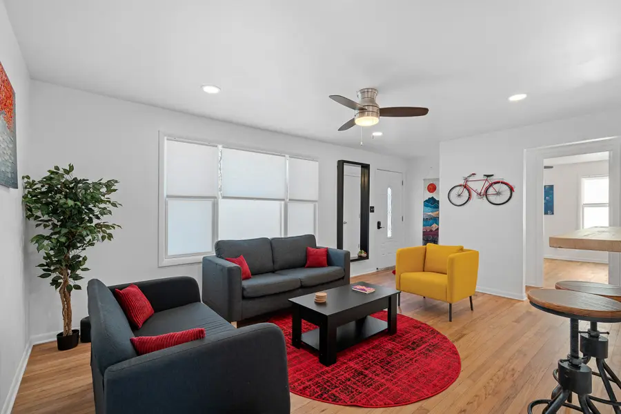 Living room with sofa, yellow armchair and red rug