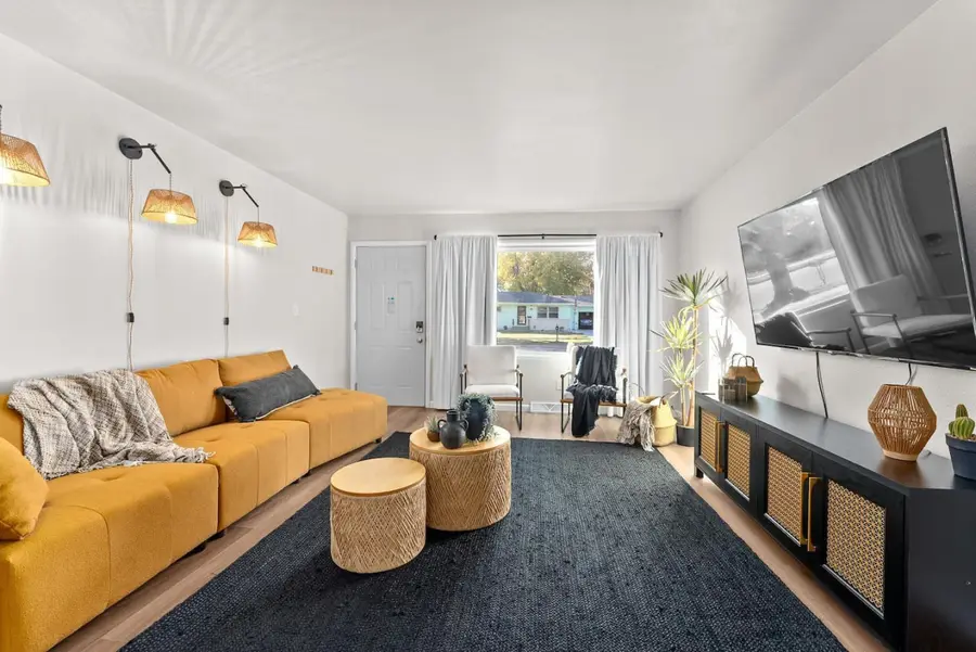38th Street Retreat living room with a mustard sofa and a wall-mounted TV