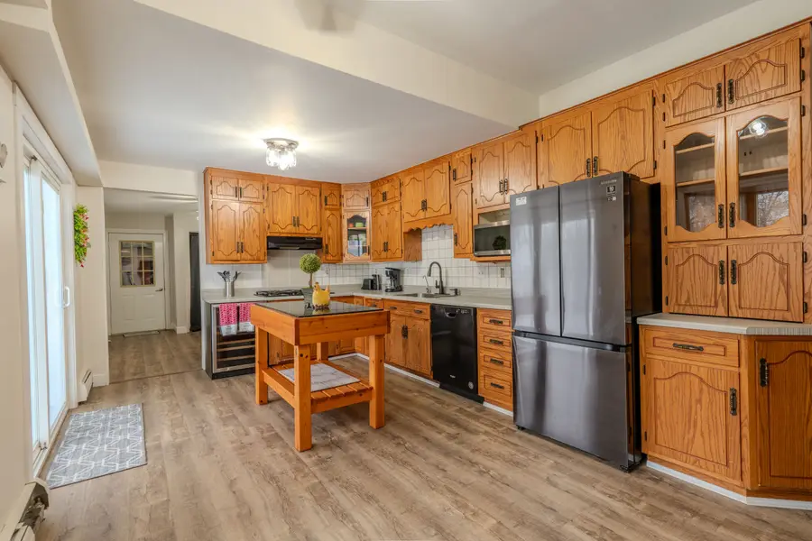 Kitchen with oak cabinets, a butcher-block island, and a stainless refrigerator