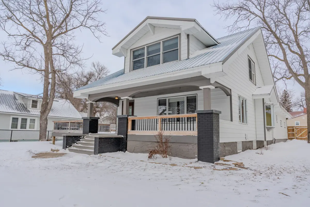 Covered front porch with brick columns and wide steps, in winter