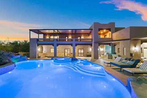 Evening pool scene with covered balcony views