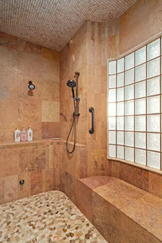 Walk-in shower with warm tile finishes