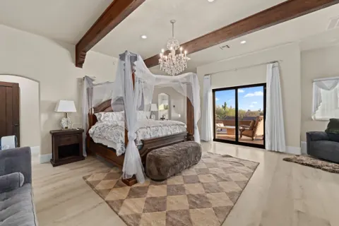 Primary bedroom with canopy bed and sitting area