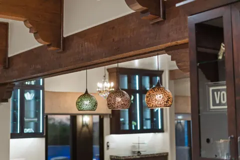Warm pendant lighting above the kitchen bar