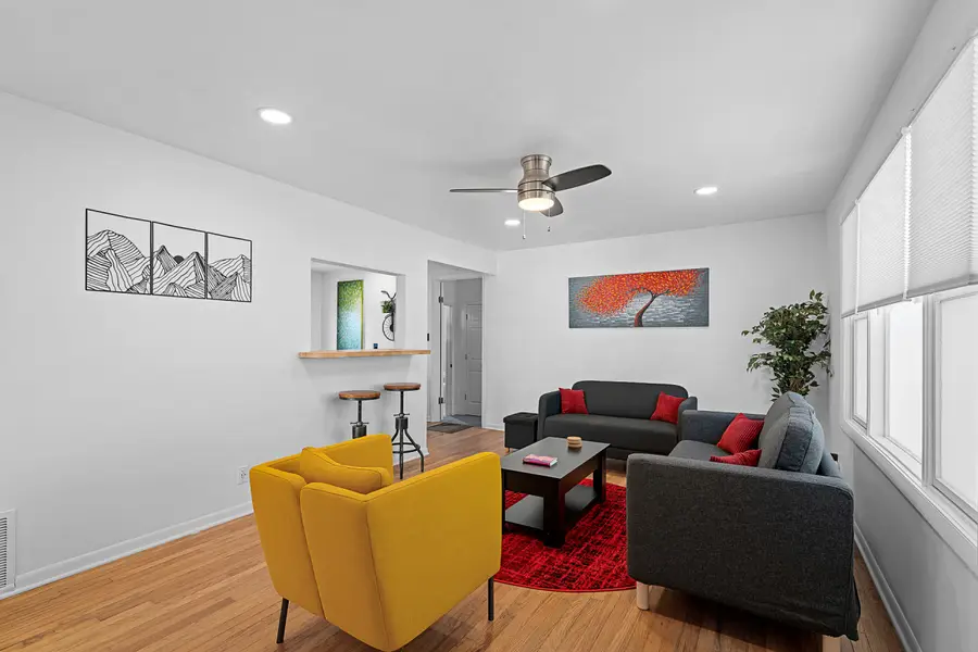 Overland Park Retreat living room with gray sofas, a yellow armchair, and a red rug