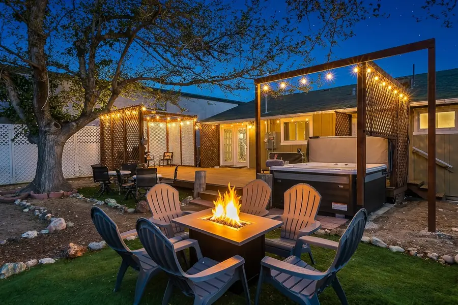 Reno Rustic Hideaway backyard with a lit fire table, Adirondack chairs, and the hot tub