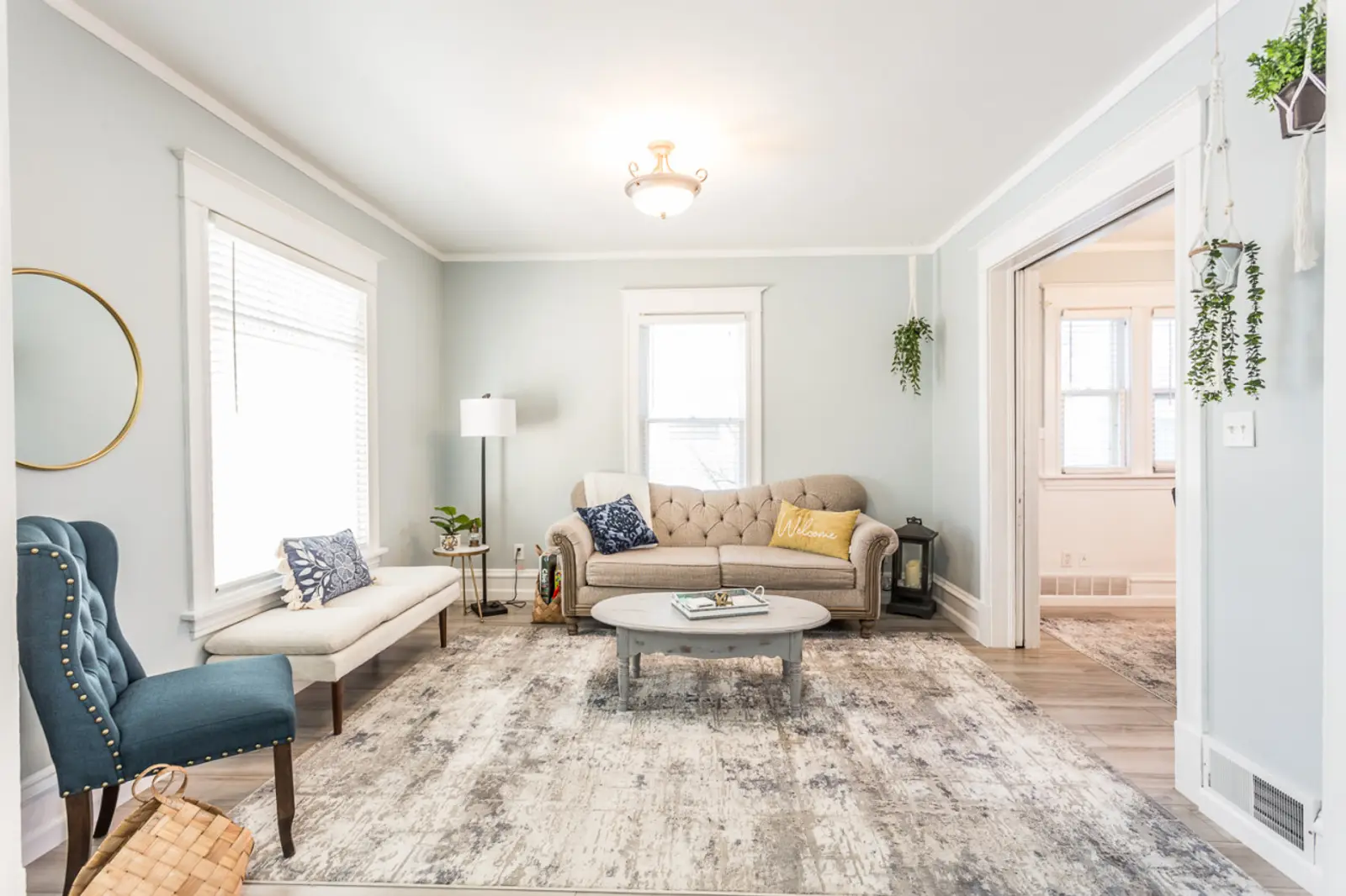 Living room with a tufted sofa, a blue armchair, and a round coffee table