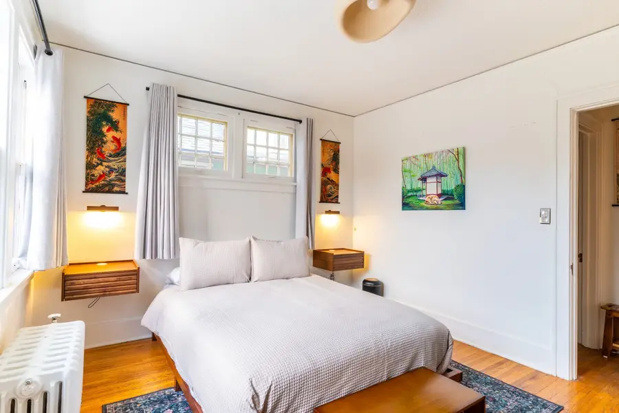 Bedroom with a queen bed, Japanese scrolls, and a painting of a teahouse