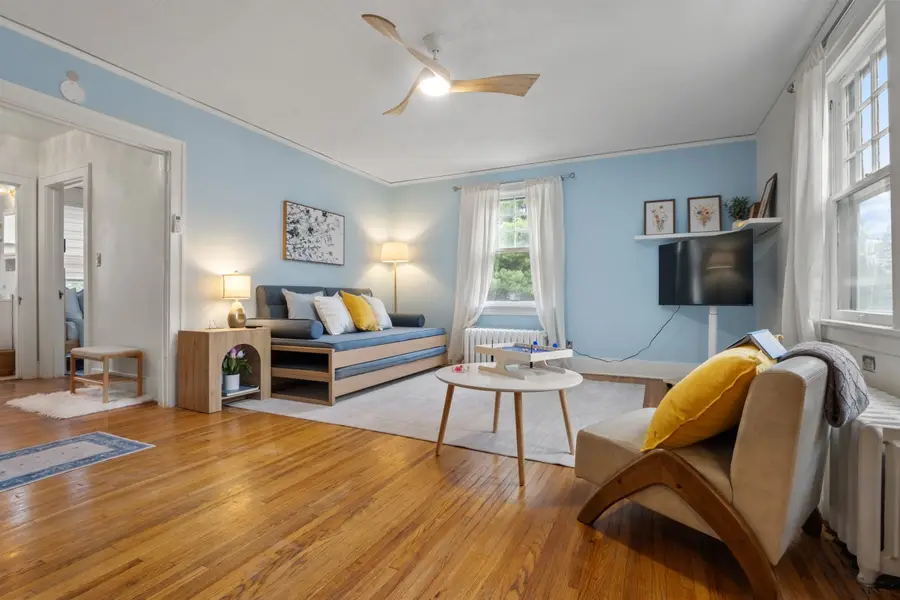 Stockholm Flat living room with soft blue walls, oak floors, and a twin daybed