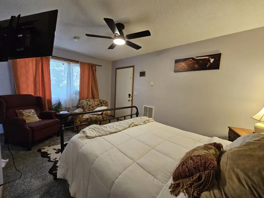 The Prospect Pine studio with a queen bed and a ceiling fan