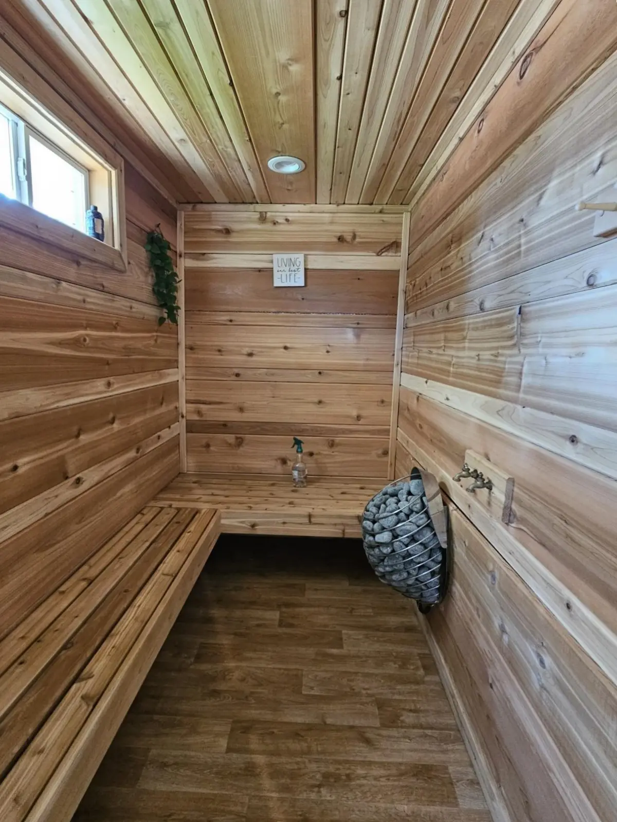 Wood-lined sauna with a bench and a stone heater