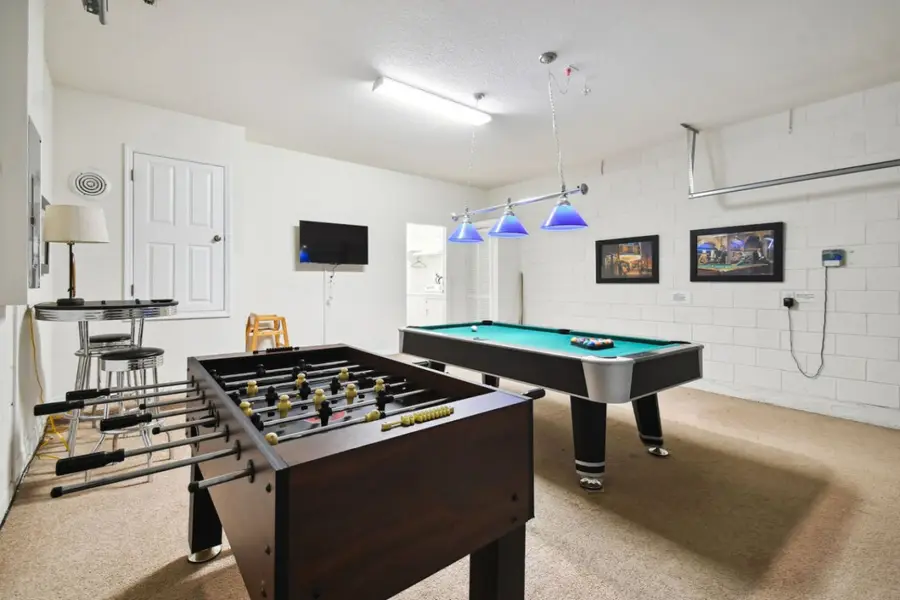 Game room with a pool table, foosball, and bar seating