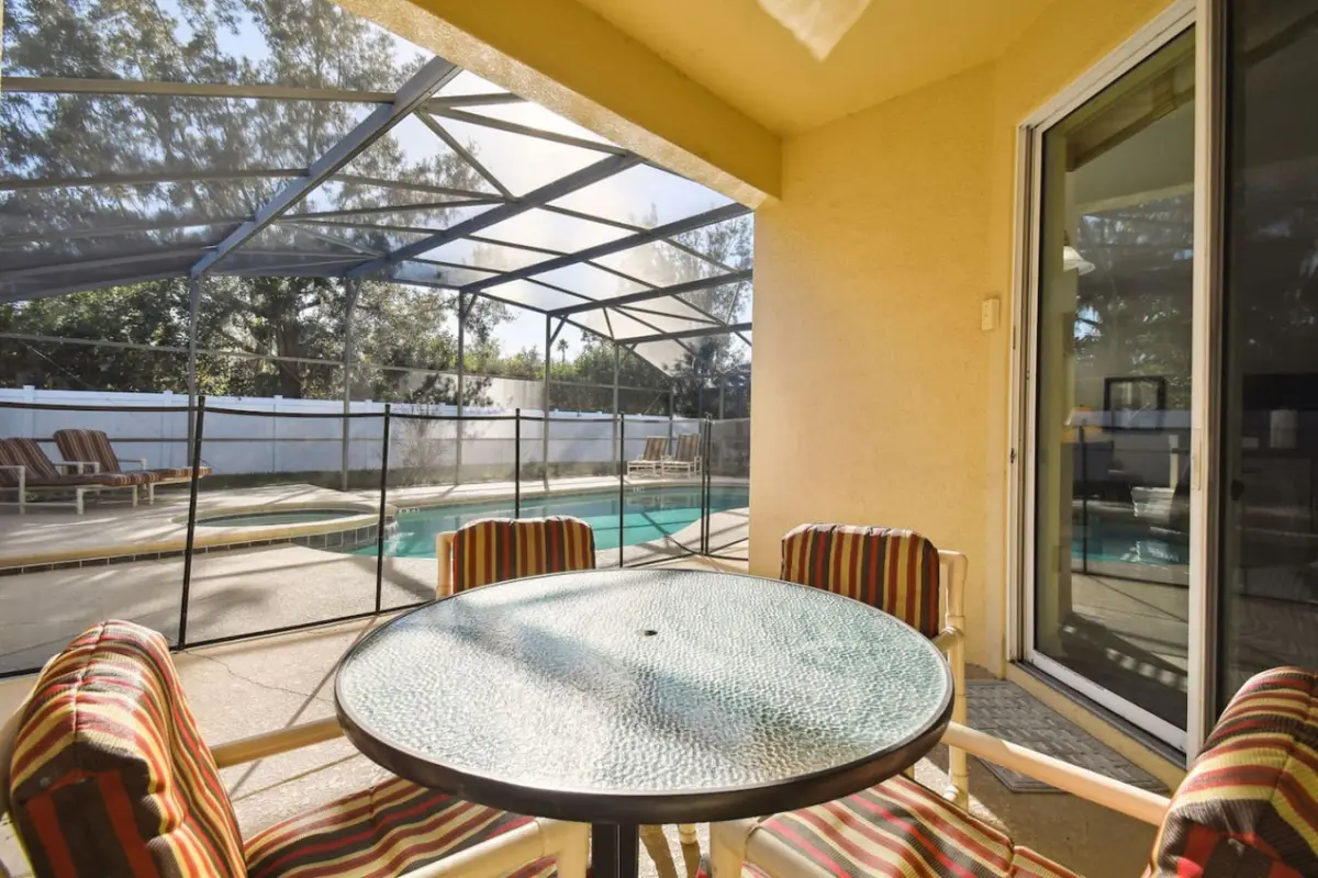 Covered patio table beside the screened pool and hot tub