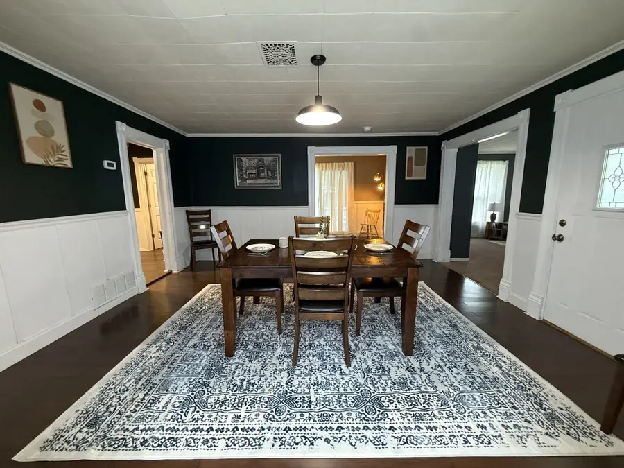 Cedar House dining room with a wood table for six and white wainscoting