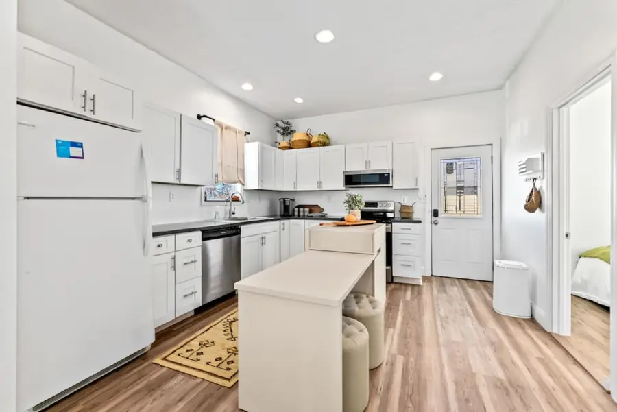 Kitchen with white cabinets and an island with round stools