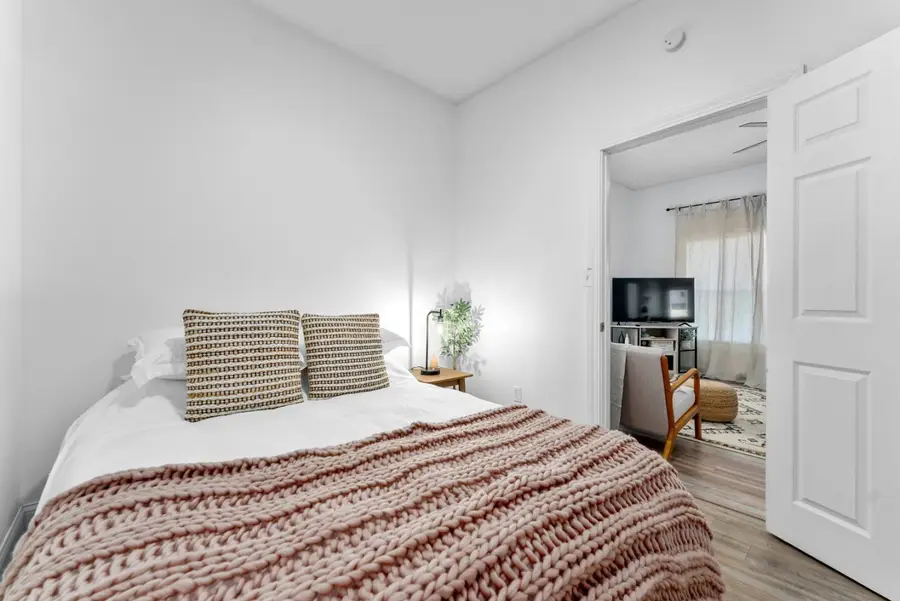 Bedroom with a queen bed, its door open to the living room