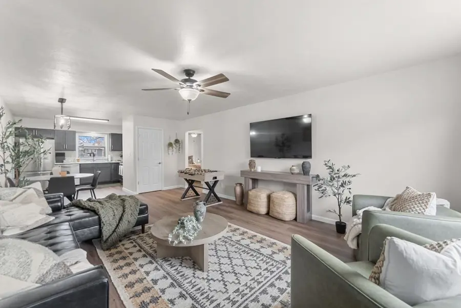 The Fern on 38th living room with a black leather sectional and a TV