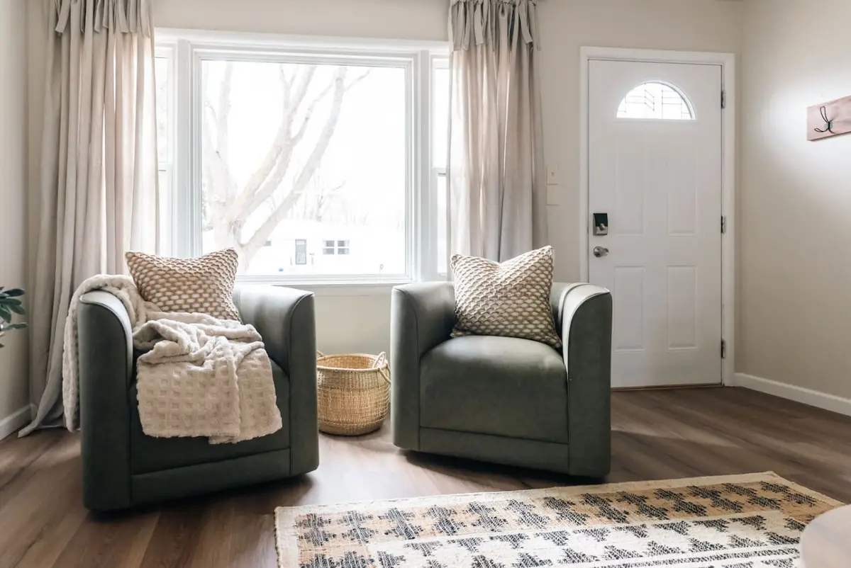 Two green armchairs by the front window