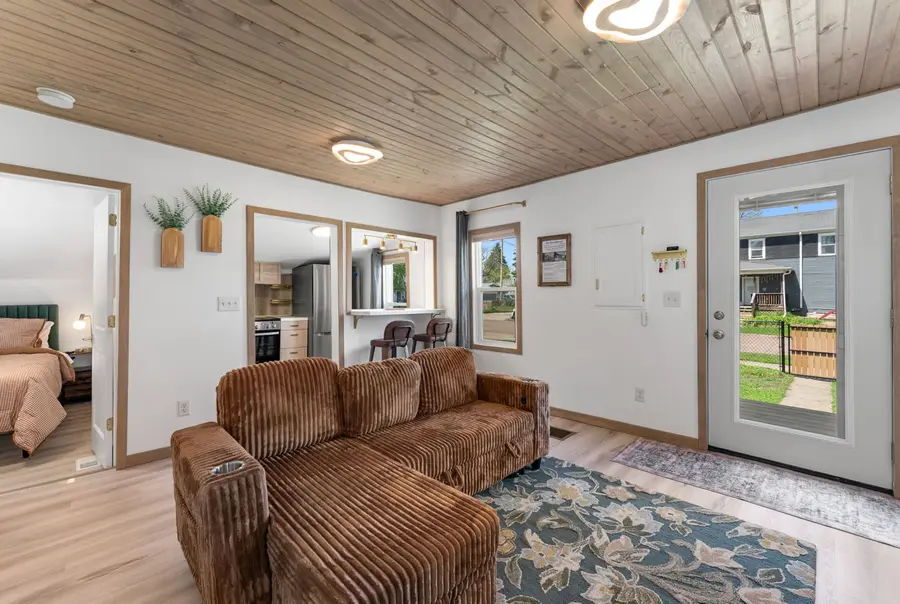 The Lumber House living room with a corduroy sectional under a wood plank ceiling