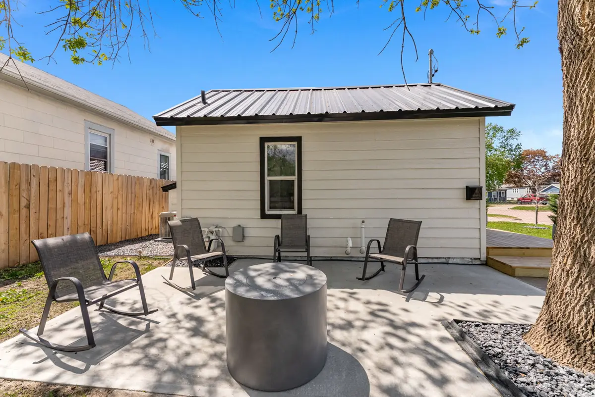 Rear patio with rocking chairs around a round fire pit