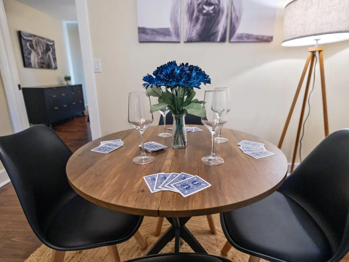 Round dining table set with playing cards and wine glasses
