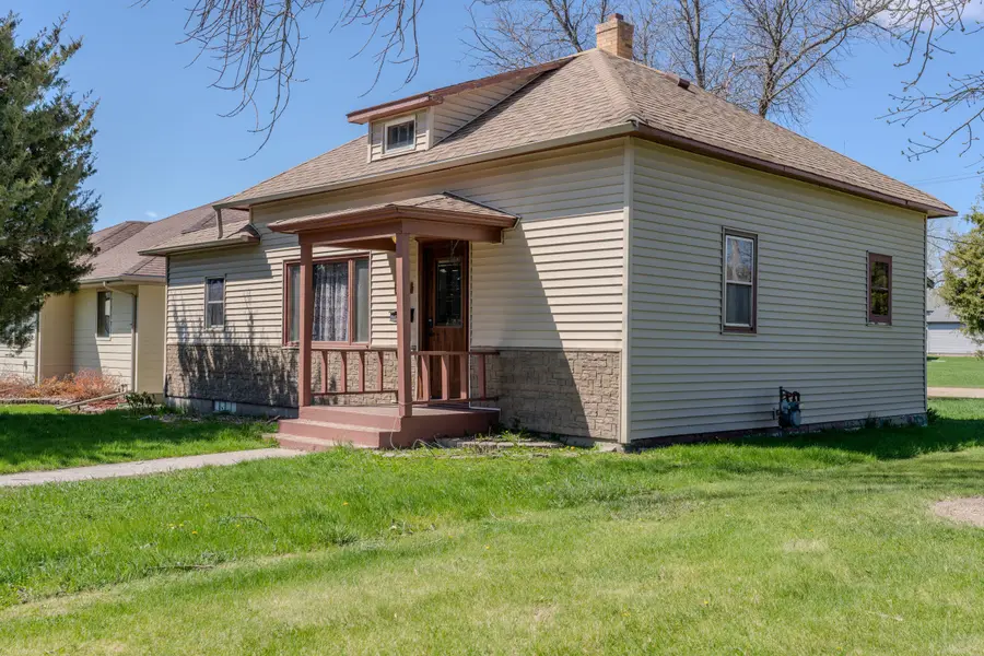 The Webster Basecamp, a tan bungalow with a covered front porch and a dormer window