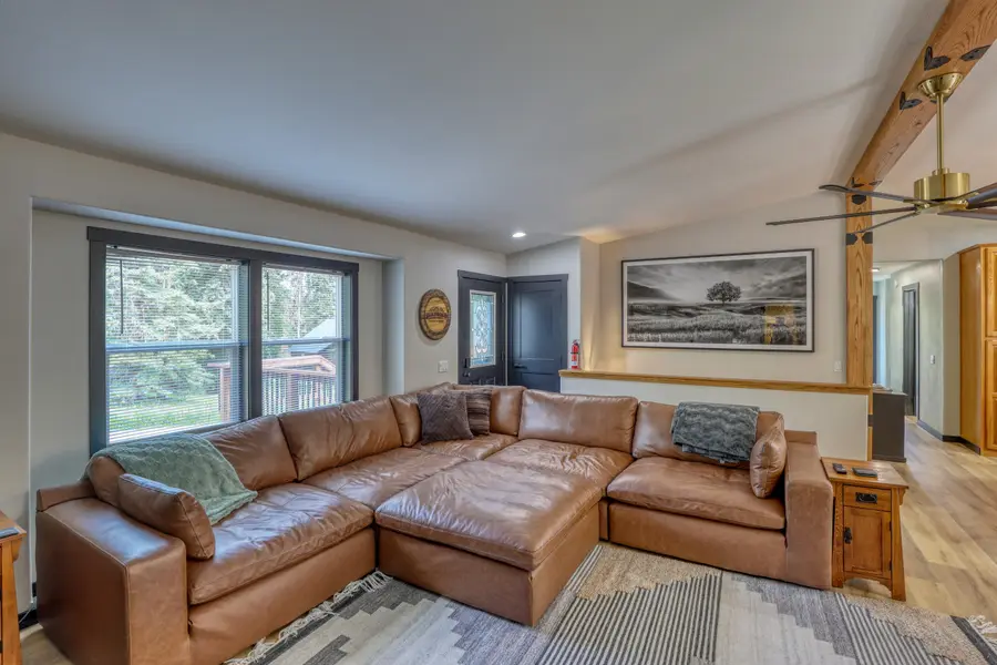 Living room with a leather sectional and windows to the trees