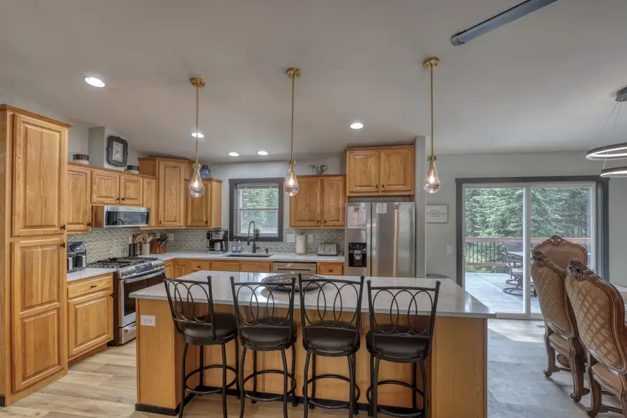 Kitchen island with four bar stools and a sliding door to the deck